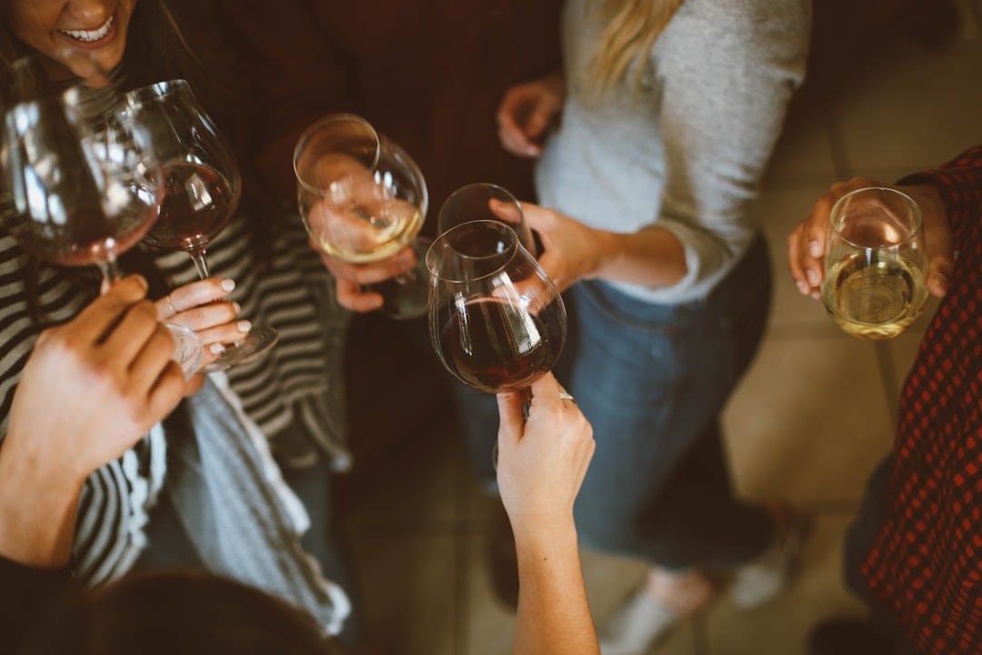 A group raising glasses of white wine together at a party