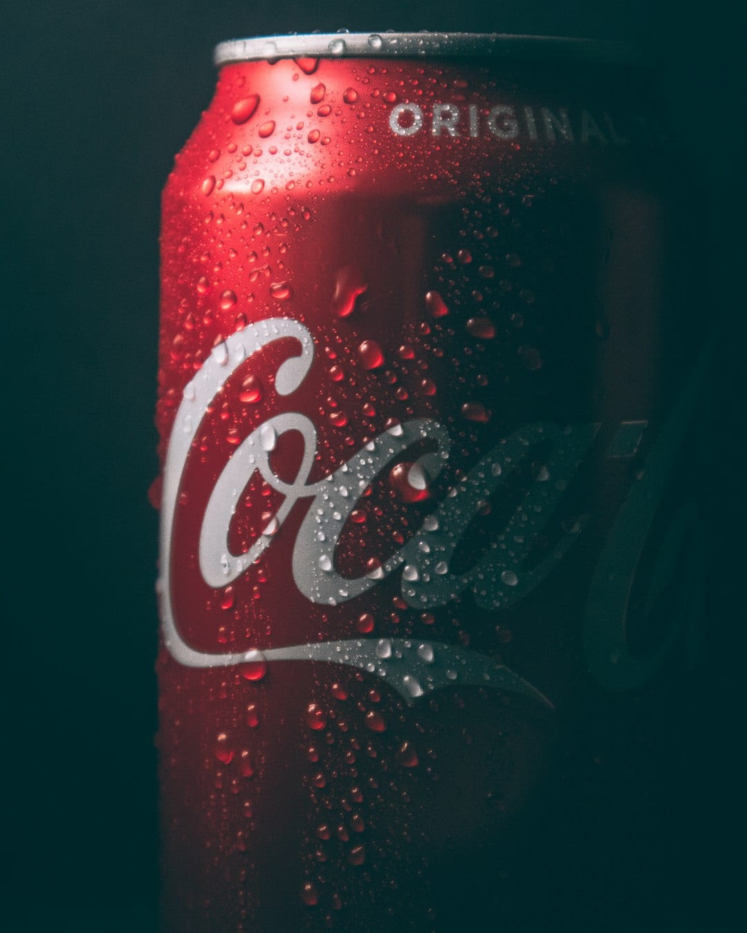 A chilled can of cola covered in condensation