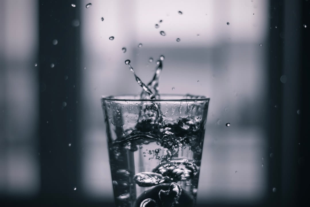 Water splashing into a glass on a dark windowsill