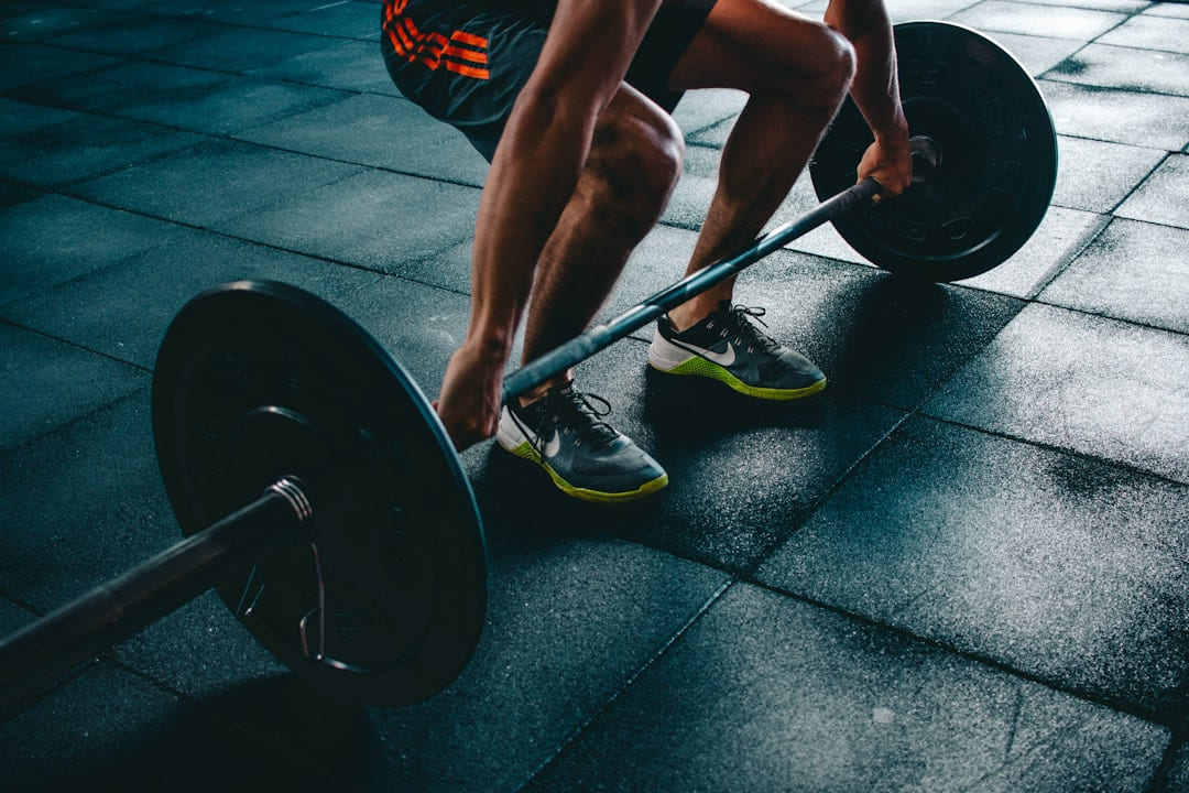 A lifter's hands gripping a barbell at the start of a pull