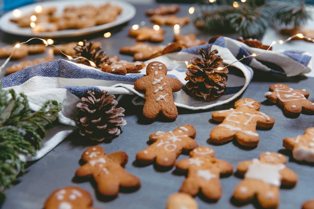 Iced gingerbread figures, pine cones and fairy lights on a table