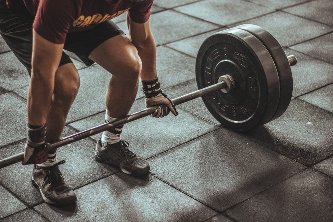 A lifter's legs and hands at the start of a deadlift