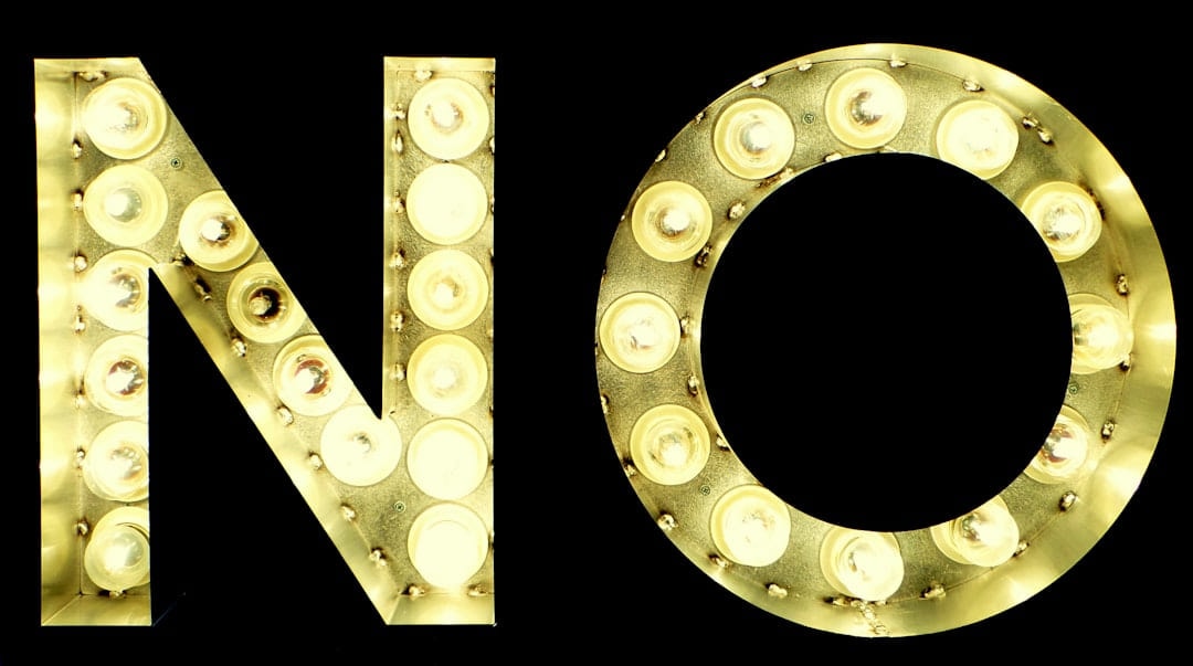 The word no spelled out in illuminated bulb letters against black