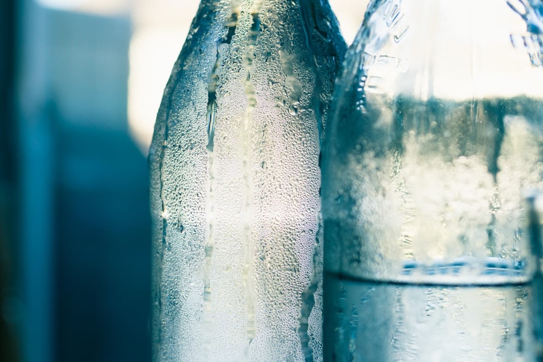 Condensation running down two chilled glass bottles